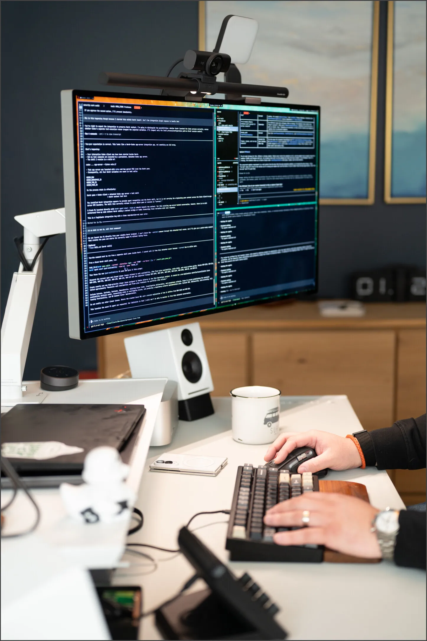 A monitor showing a terminal session, with Damian's hands on the keyboard