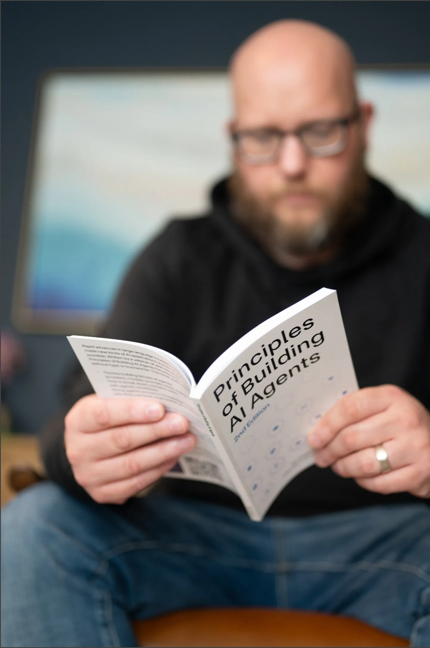 Damian reading a copy of Principles of Building AI Agents