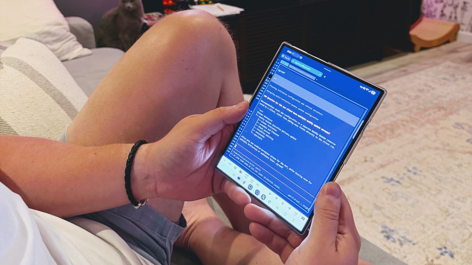 Damian on the couch holding an unfolded Galaxy Z Fold 8, with a terminal agent session open in Termius
